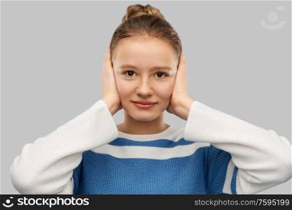 people, noise and stress concept - teenage girl closing ears by hands over grey background. teenage girl closing ears by hands