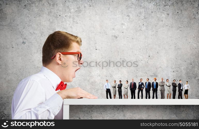 People of different professions. Businessman looking from under the table at businessteam