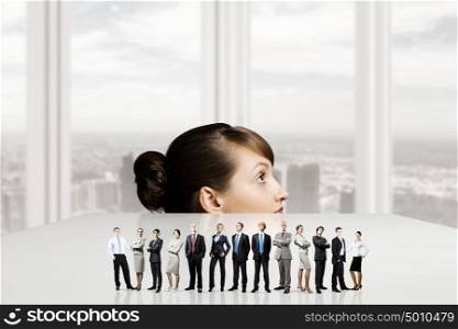 People of different professions. Businesswoman looking from under the table at businessteam