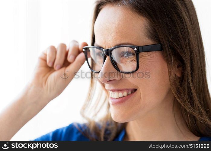 people, office and vision concept - close up of happy smiling middle aged woman in glasses. close up of smiling middle aged woman in glasses