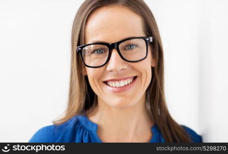 people, office and vision concept - close up of happy smiling middle aged woman in glasses. close up of smiling middle aged woman in glasses