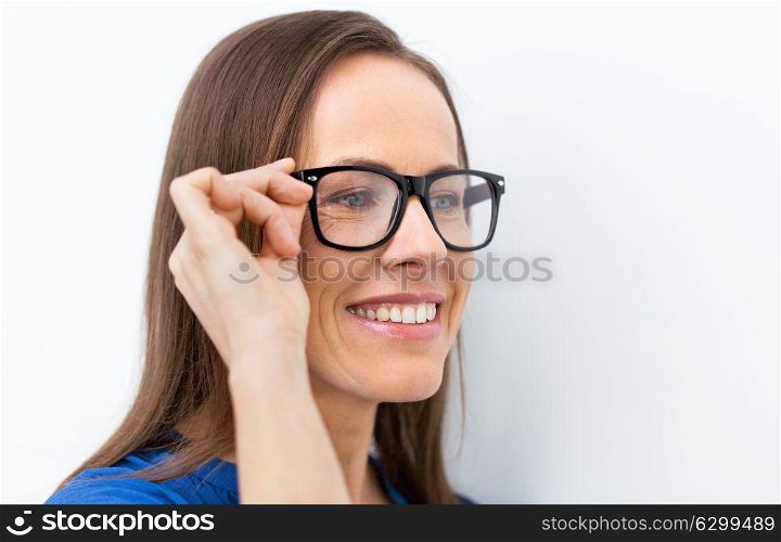 people, office and vision concept - close up of happy smiling middle aged woman in glasses. close up of smiling middle aged woman in glasses
