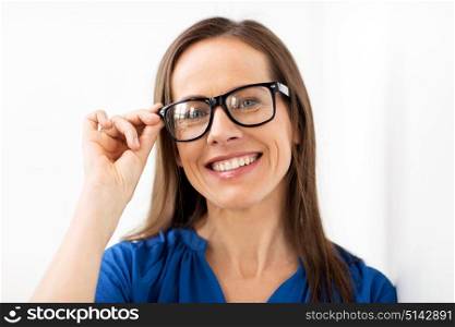 people, office and vision concept - happy smiling middle aged woman in glasses. happy smiling middle aged woman in glasses