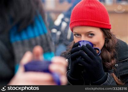 People on a Christmas market drinking punch or hot spiced wine, it is cold and they have a need to warm up