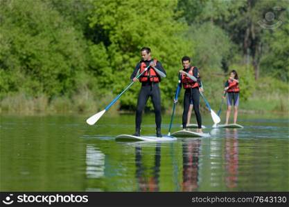 people on stand up paddleboarding
