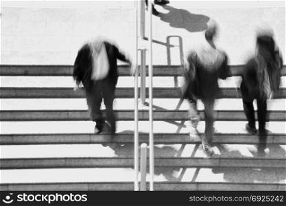 People on subway station stairway abstract motion blur. Black and white.