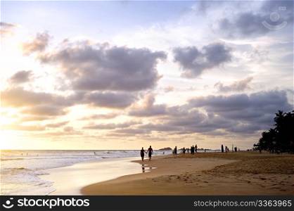 People on the ocean beach at sunset. Sri Lanka