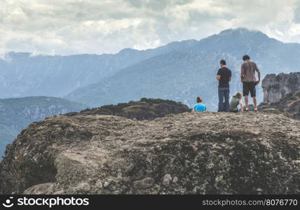 People on the top of the rocks. Cloudy sky