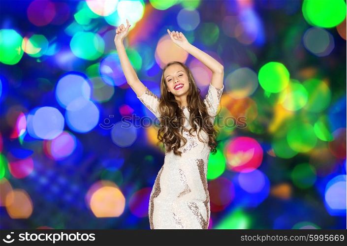people, party, holidays and fashion concept - happy young woman or teen girl in fancy dress with sequins and long wavy hair dancing over disco lights background