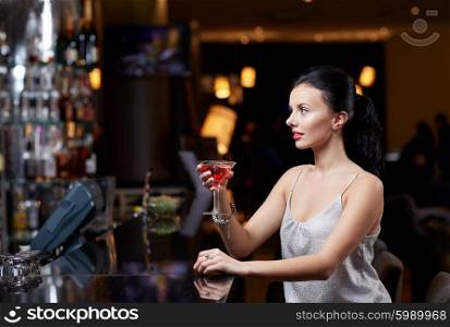 people, party, nightlife, drink and holidays concept - glamorous woman with cocktail at night club or bar