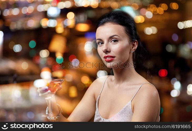 people, party, nightlife, drink and holidays concept - glamorous woman with cocktail at night club or bar