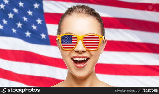 people, patriotism, national pride and independence day concept - happy teenage girl in shades with american flag