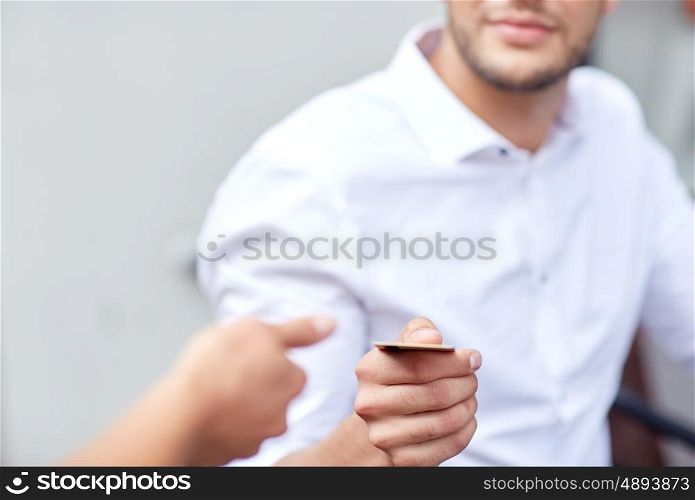 people, payment and finance concept - close up of man giving credit card to waiter