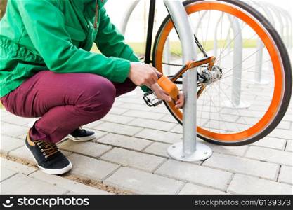 people, people, security, safety and transport - close up of man fastening bicycle lock on street parking