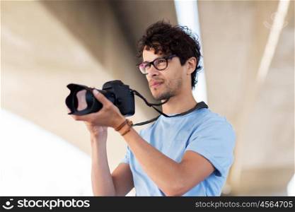 people, photography, technology, leisure and lifestyle - photographer with digital camera shooting in city