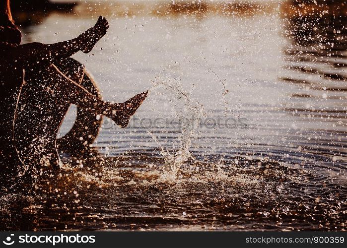 people play their feet in the water at sunset. couple splashing their feet in the water at sunset