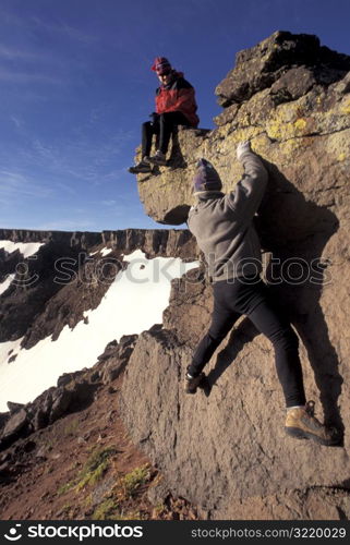 People Playing on a Rock Together