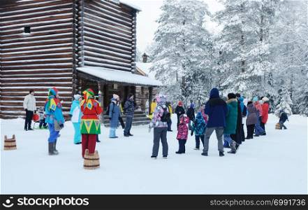 People playing on Christmas eve in the open air museum Malye Korely near Arkhanglesk, Russia. Frosty winter day.