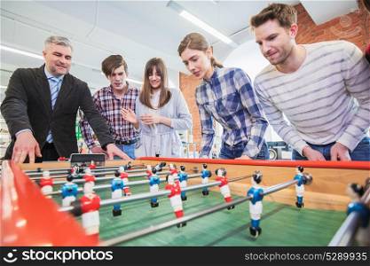 People playing table soccer. Group of happy people playing table soccer together