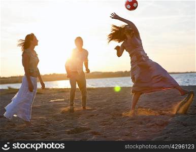 People playing with soccer ball on beach