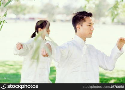 People practicing thai chi in park. People practicing thai chi in the park in the summertime