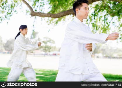 People practicing thai chi in park. People practicing thai chi in the park in the summertime