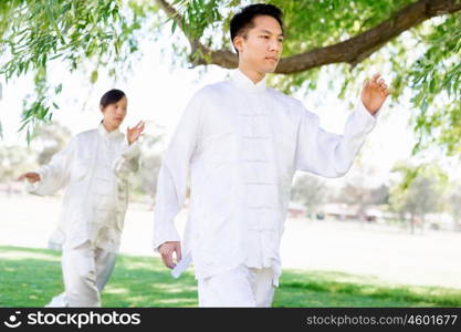 People practicing thai chi in park. People practicing thai chi in the park in the summertime