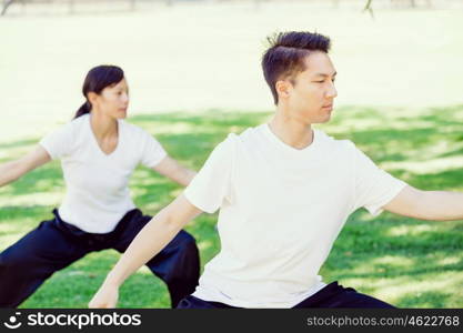 People practicing thai chi in park. People practicing thai chi in the park in the summertime