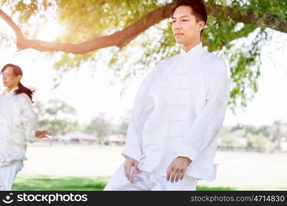 People practicing thai chi in park. People practicing thai chi in the park in the summertime