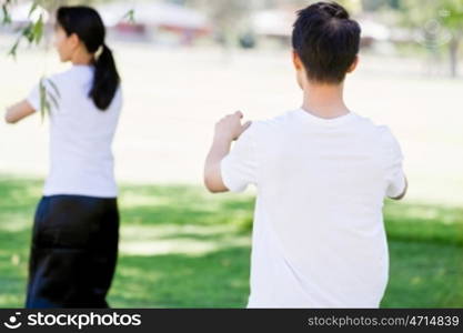 People practicing thai chi in park. People practicing thai chi in the park in the summertime