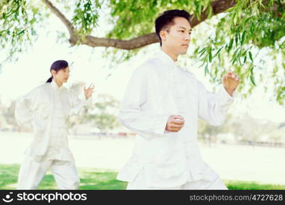 People practicing thai chi in park. People practicing thai chi in the park in the summertime