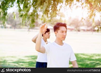 People practicing thai chi in park. People practicing thai chi in the park in the summertime