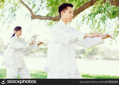 People practicing thai chi in park. People practicing thai chi in the park in the summertime