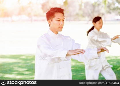 People practicing thai chi in park. People practicing thai chi in the park in the summertime