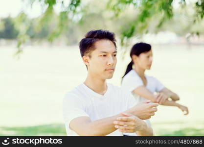 People practicing thai chi in park. People practicing thai chi in the park in the summertime