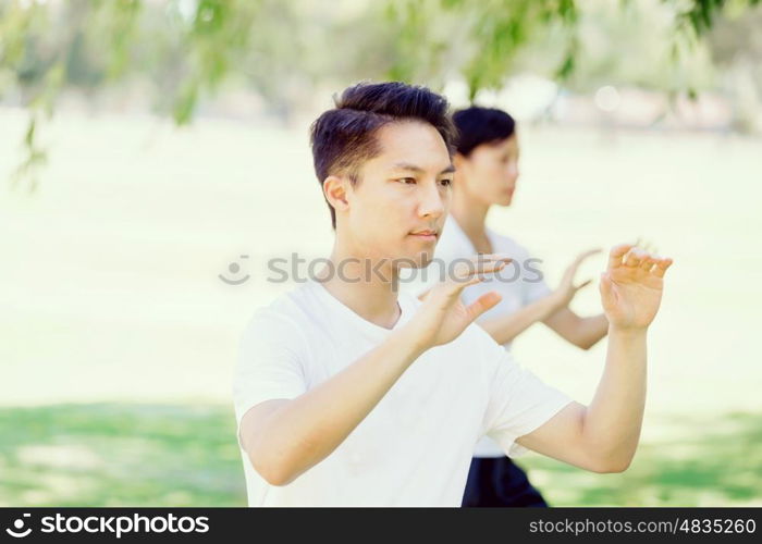 People practicing thai chi in park. People practicing thai chi in the park in the summertime