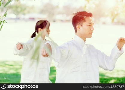 People practicing thai chi in park. People practicing thai chi in the park in the summertime