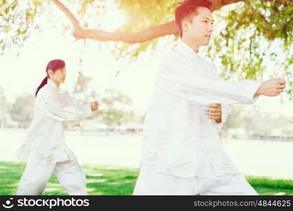 People practicing thai chi in park. People practicing thai chi in the park in the summertime