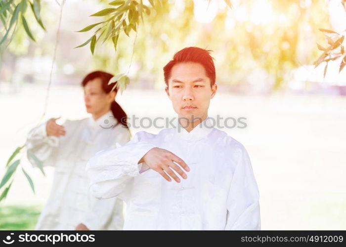 People practicing thai chi in park. People practicing thai chi in the park in the summertime