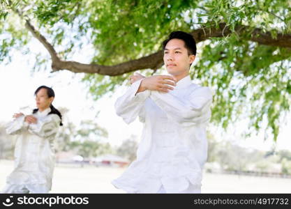 People practicing thai chi in park. People practicing thai chi in the park in the summertime