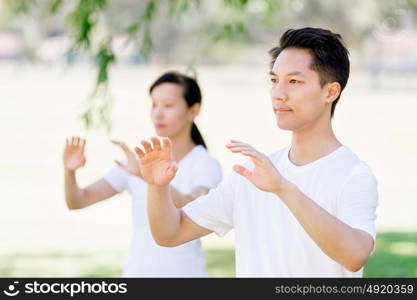 People practicing thai chi in park. People practicing thai chi in the park in the summertime