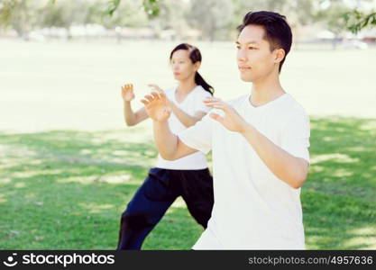 People practicing thai chi in park. People practicing thai chi in the park in the summertime