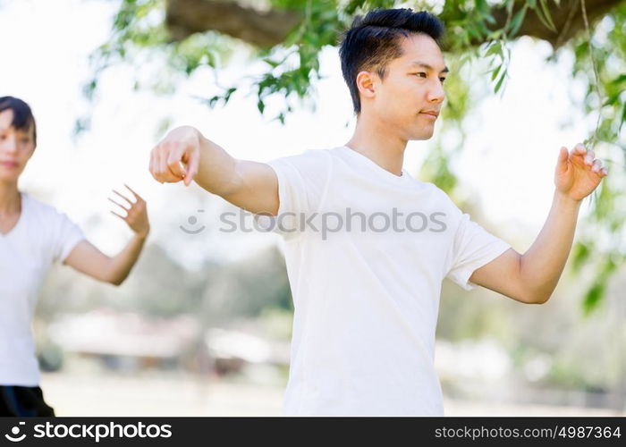 People practicing thai chi in park. People practicing thai chi in the park in the summertime