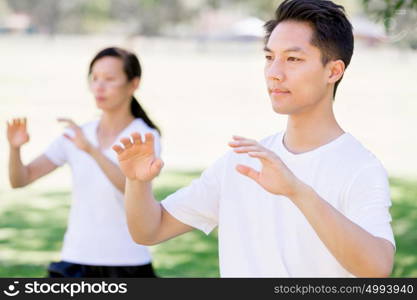 People practicing thai chi in park. People practicing thai chi in the park in the summertime