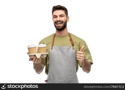 people, profession and job concept - happy smiling barman in apron holding takeaway coffee cups and showing thumbs up over white background. happy waiter with takeout coffee showing thumbs up