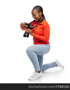 people, profession and photography concept - happy smiling woman photographer with digital camera photographing over white background. happy woman with digital camera photographing