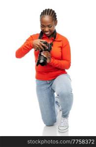 people, profession and photography concept - happy young woman with digital camera photographing over white background. happy woman with digital camera photographing