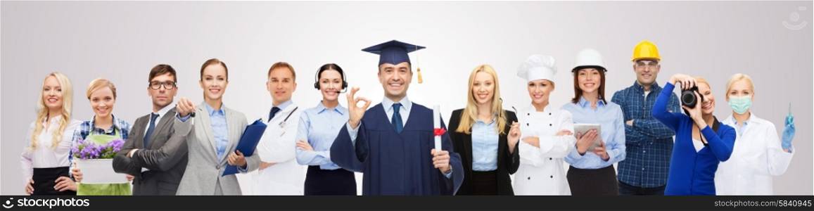 people, profession, education, gesture and success concept - happy bachelor with diploma showing ok sign over different workers and gray background