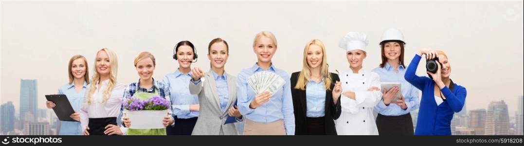 people, profession, employment, compensation and finances concept - happy businesswoman holding dollar money with group of professional workers over city background