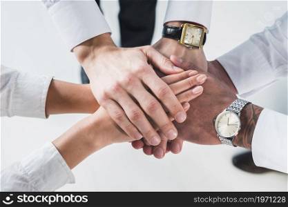 people putting stacked hands together promising help support against white backdrop. High resolution photo. people putting stacked hands together promising help support against white backdrop. High quality photo